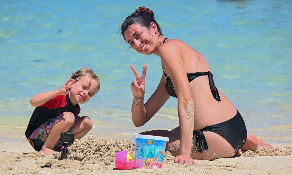 Mother and son smiling building sand castles