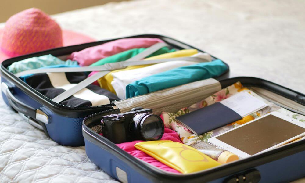 suitcase opened flat with travel items packed inside