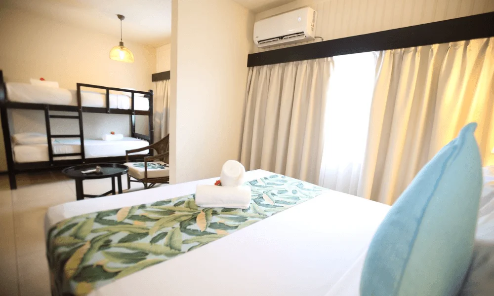 Superior family room with king bed and bunk beds in the background at Fiji Gateway Hotel